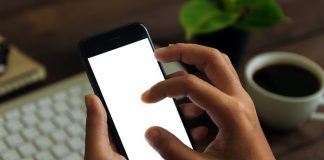 closeup hand use phone showing white screen on work desk, blank